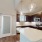Kitchen with island, brown cabinets & stainless steel appliances. 